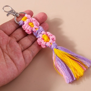 Detail of handmade woven flower keychain with colorful tassels and silver lobster clasp
