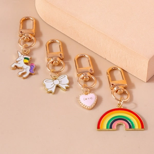 Detailed view of unicorn, rainbow, heart and bow charms on gold alloy keychains