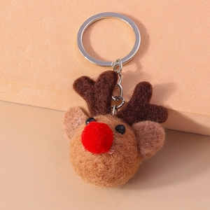 Detail of a plush reindeer keychain with soft brown wool and a bright red pom-pom nose