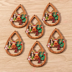 Detalle macro de adornos navideños de madera en forma de gota con renos y muñecos de nieve