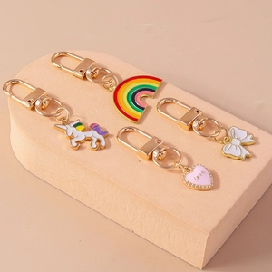 Close-up of rainbow unicorn and love heart charms on gold enamel keychains