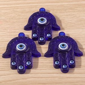 Trois pendentifs Main de Fatma en résine bleu foncé avec œil porte-bonheur et motifs