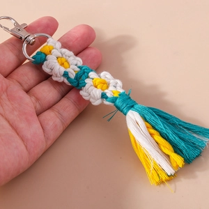 Detailed close-up of handmade woven daisy flower keychain with colorful thread tassels