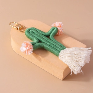 Detail of woven cactus keychain with soft white tassel and golden lobster clasp