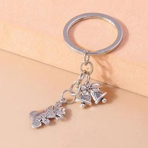 Detailed close-up of a silver Christmas stocking and bell charms on a metal keychain