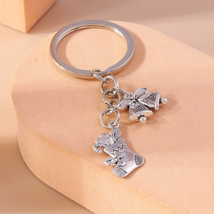 Detailed close-up of festive silver alloy bells and Christmas stocking charms on keychain