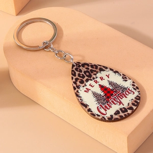 Dettaglio portachiavi natalizio in legno con stampa leopardata e albero di Natale a quadri