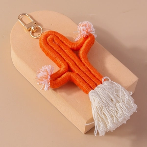 Detail of hand-woven cactus keychain with orange cotton rope and white fringe tassels