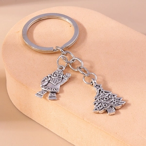 Detailed close-up of retro silver alloy Christmas tree and Santa keychain charms