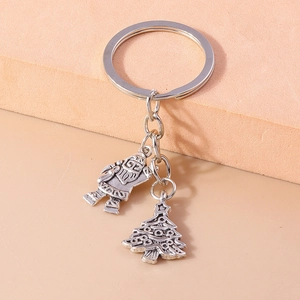 Detail of silver metal Christmas keychain featuring Santa Claus and Xmas tree pendants