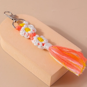 Close-up of handmade crochet flower keychain with colorful tassels and silver lobster clasp