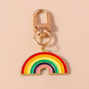 Rainbow enamel charm keychain with gold plated lobster clasp on a soft pink background