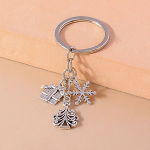 Detailed close-up of silver Christmas keychain with snowflake tree and gift box pendants