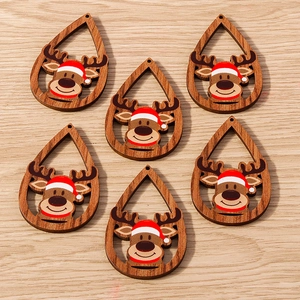 Primer plano de colgantes de madera para Navidad con renos pintados y gorros rojos