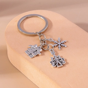Detailed macro shot of silver alloy Christmas charms featuring tree, snowflake and gift box
