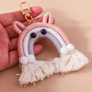 Detail of handmade cotton woven rainbow charm with soft fringe and golden lobster clasp