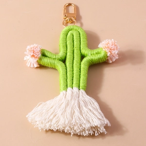 Detail of handmade knit cactus keychain with pink pom-poms and white tassels