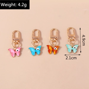 Lot de quatre porte-clés papillon colorés avec mesures de taille et de poids précises