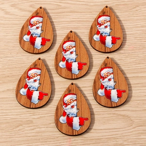 Primer plano de colgantes de madera en forma de gota con diseños pintados de Papá Noel