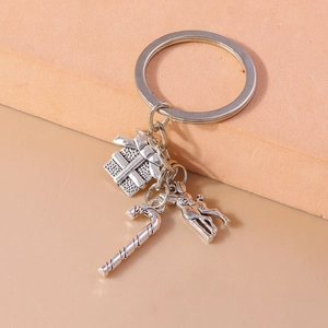 Detailed close-up of vintage silver alloy keychain with gift box, candy cane and deer charms