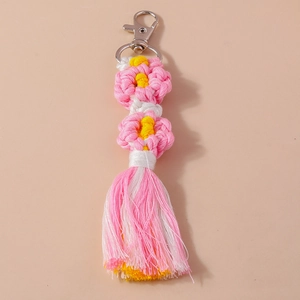 Detail of handmade woven flower keychain featuring pink and white tassels with silver lobster clasp