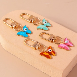 Détail de quatre porte-clés papillons colorés avec motifs d'yeux et fermoirs dorés brillants