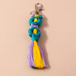Macro detail of handmade macrame floral tassel keychain with silver lobster clasp and cotton cords