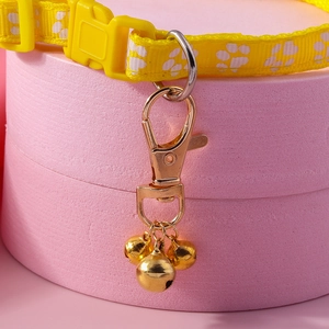 Collare giallo per animali con impronte e tre campanellini d'oro su base rosa