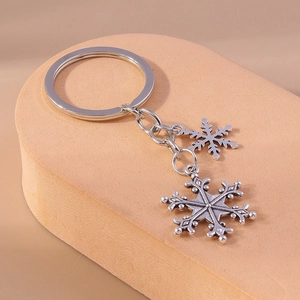 Detailed close-up of snowflake alloy keychains with beaded edges on a minimalist display