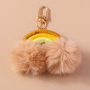 Detail of handmade woven rainbow keychain with fluffy apricot pompoms and gold metal clasp