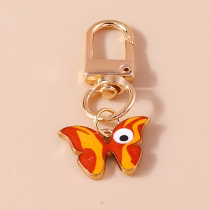 Porte-clés papillon orange avec motif œil et fermoir mousqueton doré brillant