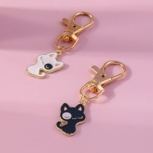 Pendentif chat mignon noir et blanc avec fermoir mousqueton doré sur fond violet