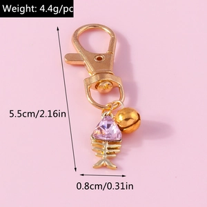 Detailed view of golden fishbone pendant with purple crystal and lobster clasp