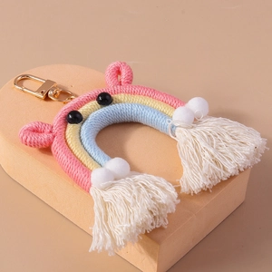 Detailed macro of handmade macaron rainbow keychain with white tassels and golden clasp