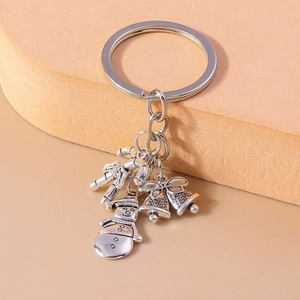 Detailed close-up of silver Christmas keychain with snowman, bells and candy cane charms