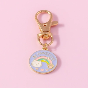 Detail of a purple enamel cat keychain featuring a rainbow and Be Pawsitive text