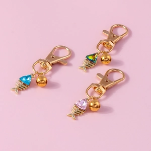 Detailed close-up of fishbone keychains with colorful gemstones and small gold bells