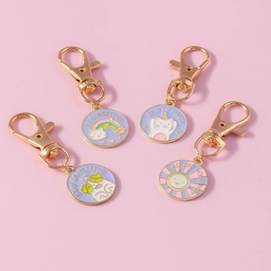 Detailed view of four colorful enamel cat and sun pendants with golden D-rings