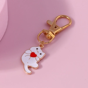 Cute white cartoon cat keychain holding a red heart with golden finish plating