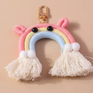 Detail of handmade rainbow keychain with colorful cotton rope, white pompons and tassels