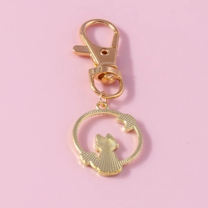 Gros plan détaillé du porte-clés doré avec pendentif chat et lune au design ajouré