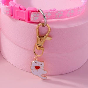 Pink pet collar with cat charm holding a red heart and white paw prints on webbing