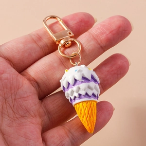 Close-up of a cute purple and white ice cream cone keychain with a gold lobster clasp