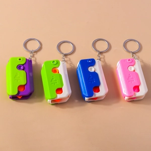 Close-up of four colorful plastic carrot knife keychains with metal rings and chains