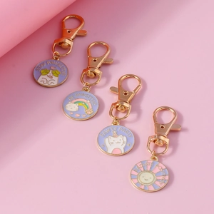 Detailed macro of four enamel cartoon pet keychains with Stay Pawsitive lettering