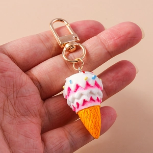 Detail of a colorful three-layer ice cream cone keychain with a golden metal hook