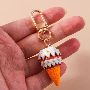 Close-up of a creative 3D resin ice cream cone keychain with a golden metal D-buckle