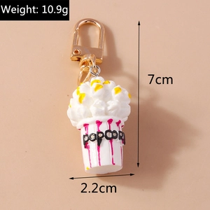 Detailed close-up of a creative popcorn keychain with red stripes and gold lobster clasp