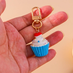 Detail eines Cupcake-Schlüsselanhängers mit blauer Basis und goldenem D-Ring-Verschluss