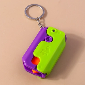 Detail view of colorful purple and green folding carrot knife keychain toy with ring